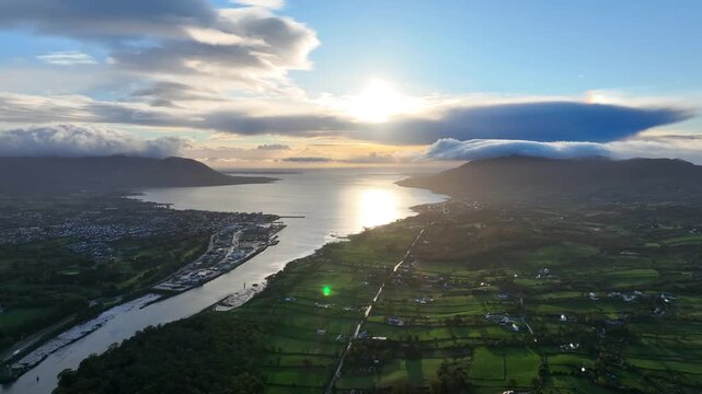 Flagstaff, County Down, Northern Ireland, November 2022. Drone tracks north to the Newry river then pulls backwards during a golden hour sunrise with Carlingford Lough and Warrenpoint in the distance.