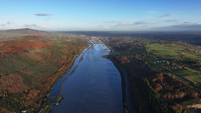 Flagstaff, County Down, Northern Ireland, November 2022. Drone pushes north west above the river towards Newry town during the early morning golden hour.
