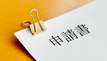 クリップで留めた用紙に申請書の文字