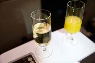 ZURICH, SWITZERLAND - JUNE 22, 2019: Welcome drink with sparkling wine and orange juice in business class during a long-haul flight in an airplane