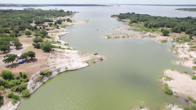Aerial footage of Steele Creek Park on Lake Whitney. People swimming and boating can be seen.