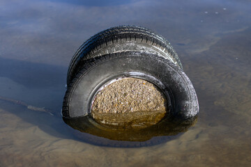 Tires with a concrete used for mooring small vessels on a lake.