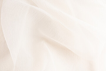 delicate soft folds of chiffon, silk, transparent fabric in champagne, ivory, beige as a wedding background with a copy space