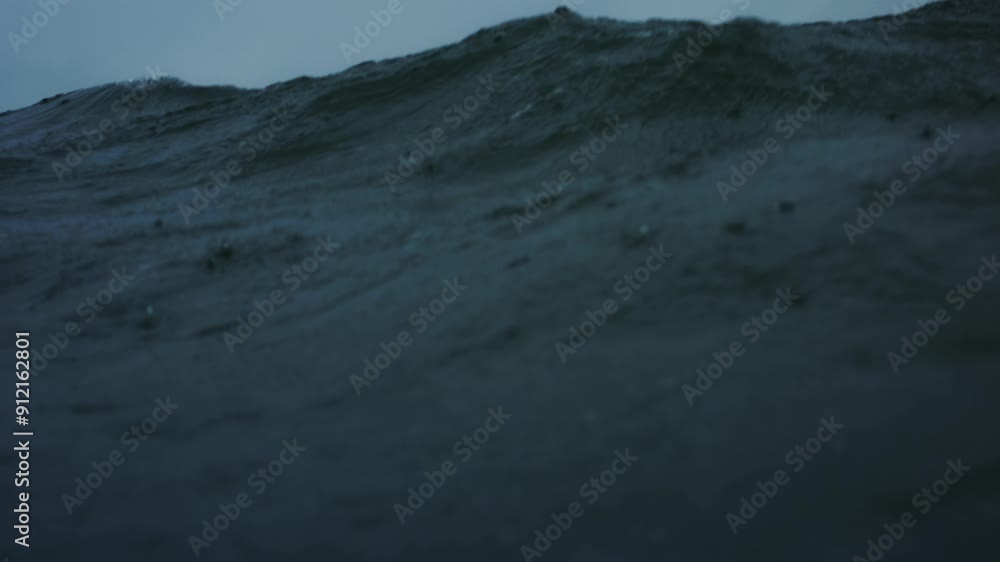 Poster frontal view of ocean water surface as rain drops fall and wave crashes exploding with power and whi