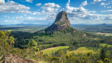 Fototapeta premium Majestic Mountain Peak Rising Above Lush Green Valley - A breathtaking view of a solitary mountain peak, its rugged slopes contrasting with the vibrant green valley below, symbolizing strength, resili
