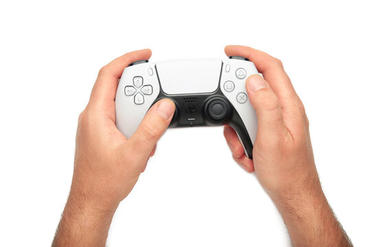 Mykolaiv, UKRAINE - July, 2024: Female hand holding a new Sony Playstation 5 DualSense white controller isolated on white background.