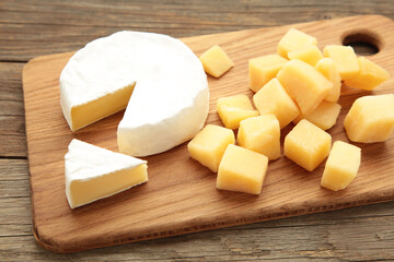 Parmesan cheese with camembert on cutting board.