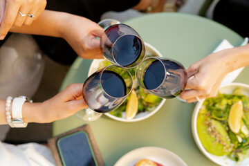 Top view of group of friends cheers with red wine. dinner table top view