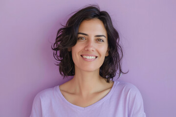 Fototapeta premium Woman with short brunette curls smiling gently against a soft purple background