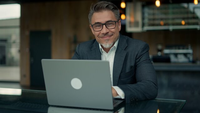 Business portrait - businessman with laptop at cafe