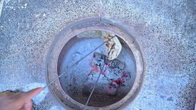 Cooking Roti or bread inside Tandoor. Tandoori roti cooking making of tandoori roti, tandori naan