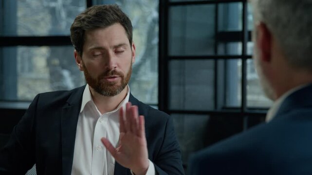 Two Caucasian men businessmen business partners talk at negotiation in office dissatisfied man client refuse offer unhappy with deal refusal frustrated customer waving head no negative answer bad idea