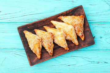 Homemade triangle puff pastry with meat on rustic background . Samosa