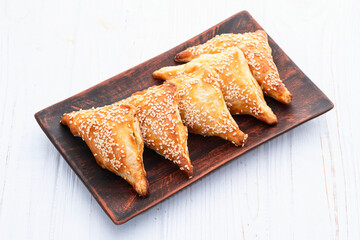 Homemade triangle puff pastry with meat on rustic background . Samosa