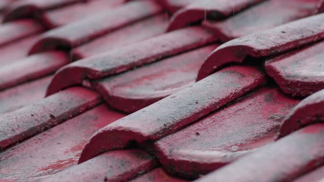 Gentle rain pattering on a weathered red tile roof
