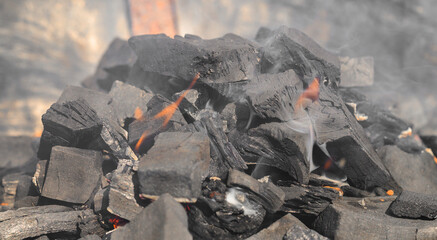 Rozpalony węgiel drzewny stojący w płomieniach, palenisko gotowe do grillowania 
