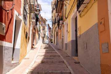 Photo of the beautiful town of Villajoyosa in Spain showing a small street with the colourful...