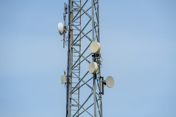 Zbliżenie na urządzenia nadająco odbierające sygnały fal radiowych na stalowej wierzy telekomunikacyjnej, 