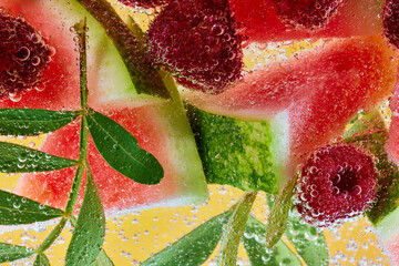 Fresh watermelon and raspberries with green leaves, immersed in sparkling bubbles. Refreshing...