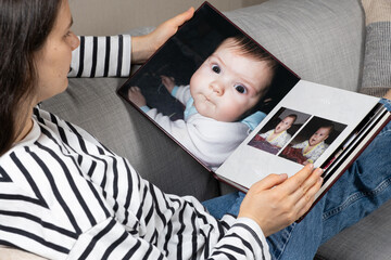 A woman looks at a photo book about her baby.