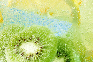 Juicy kiwi and lemon slices immersed in fizzy water, capturing essence of refreshing tropical treat...