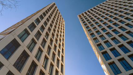 Moscow May 10 2024, Two tall buildings with many windows and a clear blue sky in the background. The buildings are very tall and have a modern look.