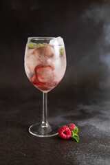 Icetea with raspberry and mint on dark background