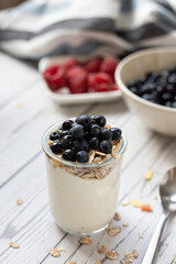 Granola with yogurt and berries in a jar. Breakfast parfait with muesli, yoghurt and blueberries