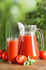 Tasty tomato juice, basil and fresh vegetables on wooden table outdoors