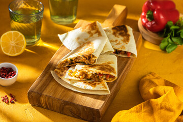 Delicious Flatbreads with Savory Filling Laid Out on a Wooden Board. Quesadillas with chicken breast, corn, red pepper, tomatoes
