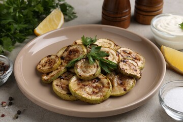 Tasty grilled courgette slices served on grey table