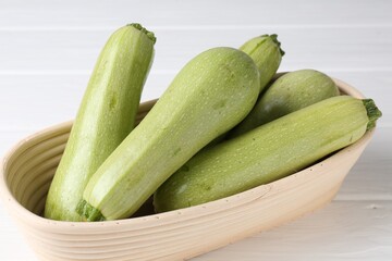 Fresh ripe zucchinis on white wooden table, closeup