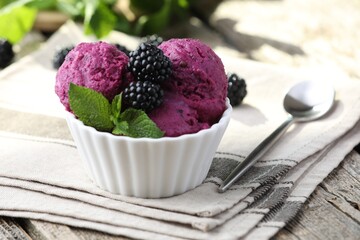 Delicious blackberry sorbet, mint and fresh berries on wooden table, closeup