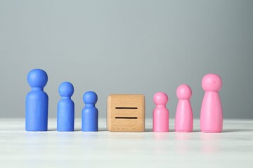 Gender equality concept. Cube with equals sign between male and female figures on white table