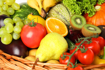 Different fresh fruits and vegetables in wicker basket, closeup