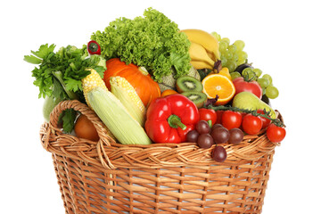 Different fresh fruits and vegetables in wicker basket isolated on white