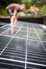 a male craftsman or electrician installs solar modules