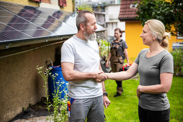 a craftsman or electrician shakes hands with a customer