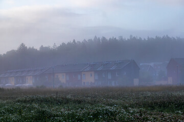 Stockholm, Sweden Row houses in a field in the fog in the Upplands Vasby suburb.