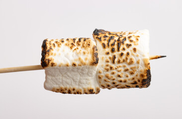 toasted marshmallow on a stick on a white background.