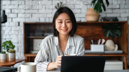 Fototapeta premium A beautiful professional woman uses a laptop in a modern office