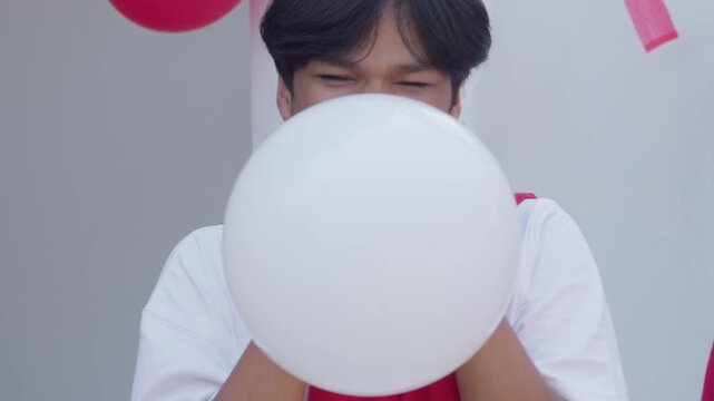 Happy Young Asian Friends Blowing Balloon Together On Indonesian Independence Day Competition