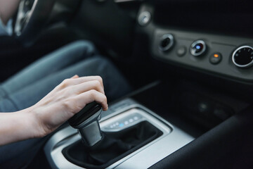 Naklejka premium Car, driver, automatic gearbox, shift knob, steering wheel a person is driving a car, adjusting the automatic gearbox using the shift knob located on the steering wheel for better control