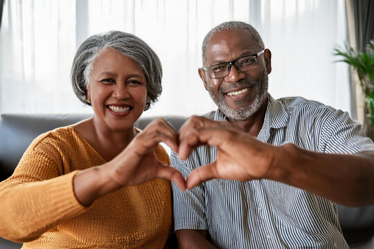 portrait happy african american middle aged elderly retired family couple making heart gesture hands fingers