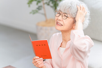 年金手帳を確認するシニア女性
