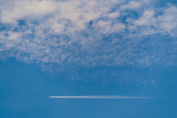 Flight in blue sky under white clouds