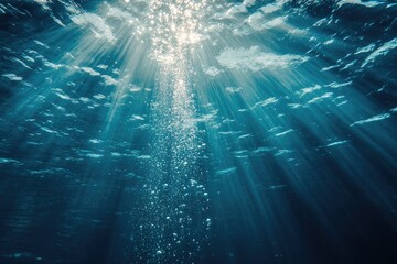 A clear blue ocean with sunlight shining through the water. The sunlight creates a beautiful and serene atmosphere