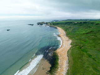 Einsamer Sandstrand an der gr&uuml;nen K&uuml;ste von Nordirland an einem bew&ouml;lkten regnerischen Tag