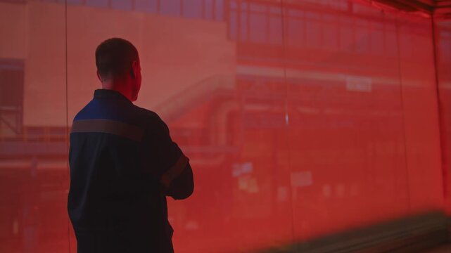 A man in a fireproof suit stands in the smelting shop of a metallurgical plant.