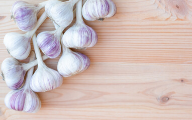 Garlic lying on a wooden background, harvest season, autumn preparations. High quality photo